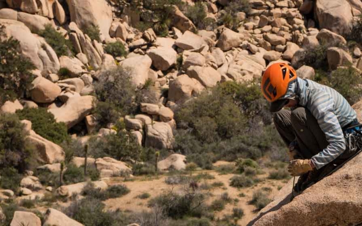 a person wearing a helmet rests on a rock during a gap year course with outward bound